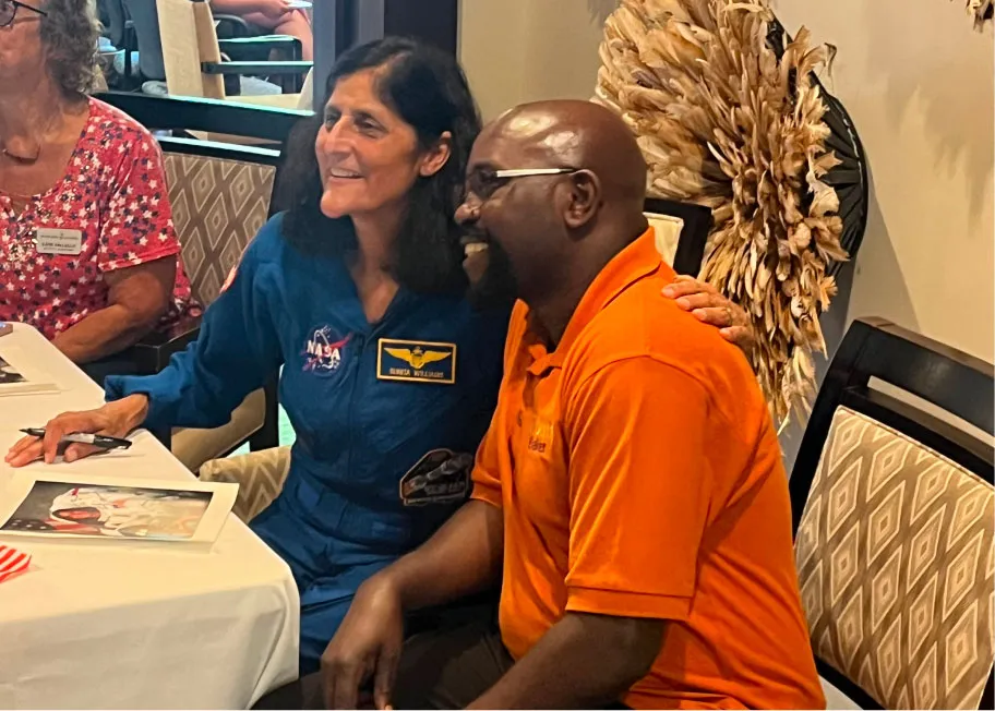 Suni Williams sitting down and laughing with a man